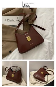Detail view of crescent dark brown leather bucket bag with golden buckle and sleek design