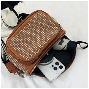 Vue intérieure du sac bandoulière en daim marron avec strass montrant la capacité