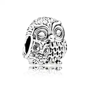 Dettaglio di un charm a forma di gufo in argento vintage con piume finemente incise