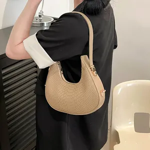 Beige crocodile embossed crescent armpit bag with golden hardware for stylish women