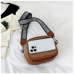 Détail du sac bandoulière marron avec strass, sangle chevron et taille réelle