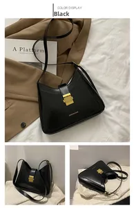Detail of black PU leather bucket bag with gold buckle and fashion bag logo lettering