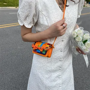 Mini color-block leather crossbody bag with chunky orange chain detail for women