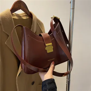 Deep burgundy minimalist bucket bag with gold buckle and adjustable strap