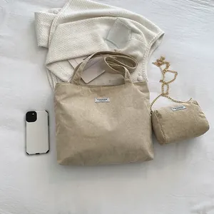 Detail view of corduroy tote bag set with FASHION label and gold chain strap bag