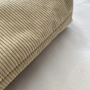 Detailed macro view of the soft beige corduroy fabric texture and vertical striped pattern