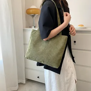 Moss green corduroy tote bag worn by a model in a cozy indoor home setting