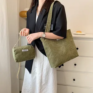 Detail of olive green corduroy tote bag and mini chain pouch with fashion label