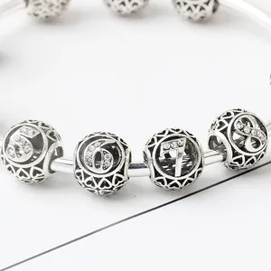 Détail des perles de cœur évidées en argent avec numéros de cinq à huit sertis de strass fins