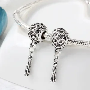 Macro shot of antique silver snake chain bracelet with hollow beads and tassel charm