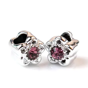 Detail of silver five-petal flower charms with pink purple crystal for DIY bracelets
