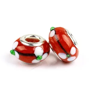 Close-up of two red glass floral beads with silver cores for DIY jewelry making
