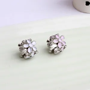 Macro detail of magnolia flower beads with pink and white enamel for DIY bracelets