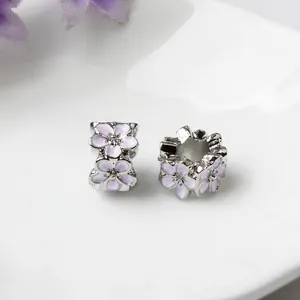 Detail of silver alloy beads with pink floral enamel patterns for DIY bracelets