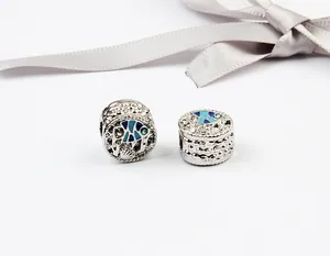 Macro de perles de poisson en argent avec émail bleu et texture de vagues sur fond blanc