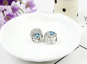 Détail de breloques poissons tropicaux en argent avec émail bleu et strass brillants