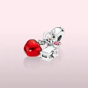 Detalle de dije de manzana roja con cofre grabado y colgante de gema rosa fina