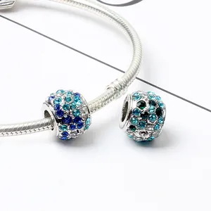 Detail of silver snake chain bracelet with sparkling blue and green crystal charms