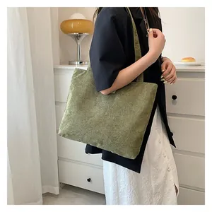 Detail of avocado green corduroy tote bag showing fine ribbed texture and shoulder strap