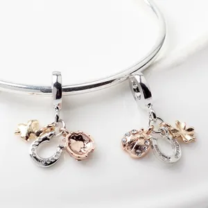 Detailed macro view of lucky horseshoe, ladybug, and four-leaf clover charms on a silver bangle