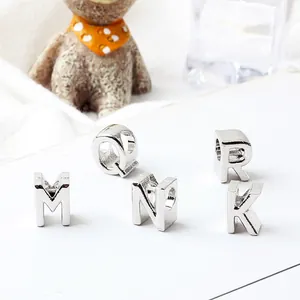 Macro shot of silver letter beads with threading holes for DIY bracelet jewelry making