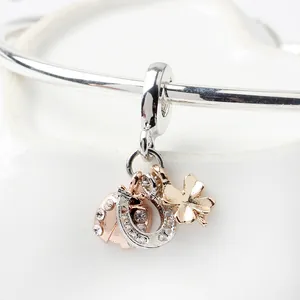 Silver horseshoe clover and rose gold ladybug charm pendant with zircon on a bracelet