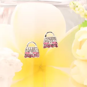 Nahaufnahme silberner Handtaschen-Ohrringe mit rosa Kristallen und Schleifendetails