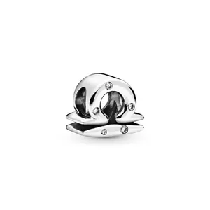 Macro view of polished silver Libra zodiac charm bead with shimmering cubic zirconia stones