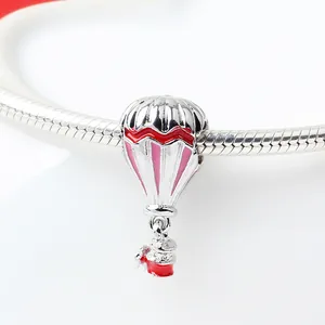 Silver hot air balloon charm with red waves and pink enamel on snake chain bracelet