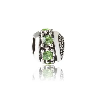 Vintage silver hollow cylinder charm bead with three round emerald green crystal accents