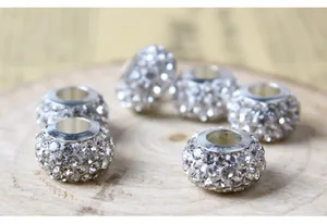 Vista macro de cuentas de plata con agujero grande y brillantes cristales de strass