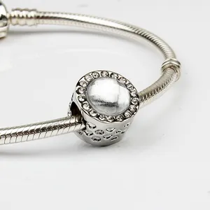 Dettaglio macro del bracciale a maglia snake con ciondolo rotondo in pavé di zirconi