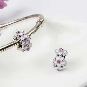 Dettaglio macro delle perline di magnolia smaltate e ciondoli in zircone rosa su catena