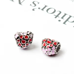 Dettaglio di ciondoli a cuore in argento con smalto rosso e rosa per braccialetti
