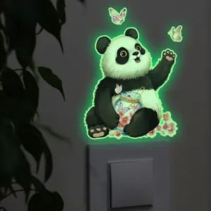 Sticker mural lumineux avec panda et bocal sur un interrupteur mural blanc