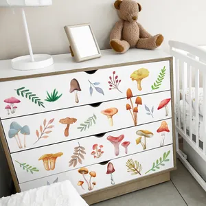 Close-up of watercolor mushroom decals on a white cabinet for cozy home nursery decor
