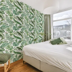 Minimalist tropical green leaf wallpaper featuring monstera and palm leaves for wall decor