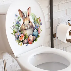 Gros plan d'un autocollant aquarelle lapin et fleurs posé sur un abattant de WC blanc