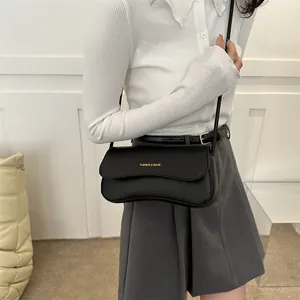Sac bandoulière style français en cuir noir mat avec rabat ondulé et lettrage doré chic