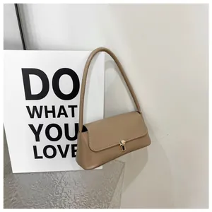 Close-up of the khaki underarm bag featuring a golden metal buckle and refined leather texture