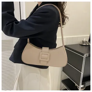 Minimalist beige faux leather baguette bag with oversized square buckle on shoulder strap