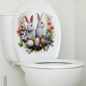 Détail de stickers de Pâques avec lapins et fleurs sur un abattant de WC blanc