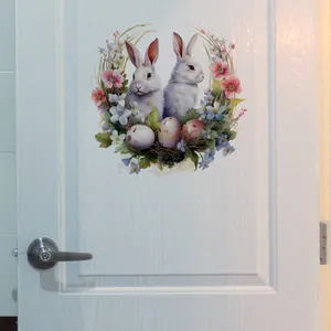 Détail d'un autocollant couronne de fleurs lapin de Pâques sur une porte en bois blanc