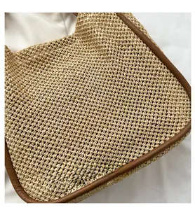 Dettaglio della borsa in paglia intrecciata con finiture in pelle marrone e trama fine
