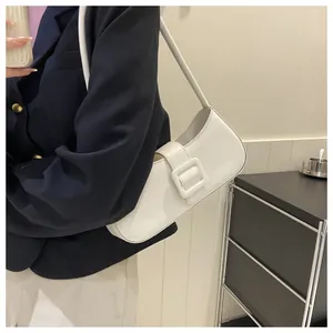 Detailed view of a white baguette bag with large square buckle and smooth leather finish