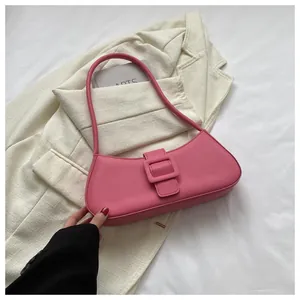 Detailed view of pink baguette bag with large buckle on minimalist blazer background