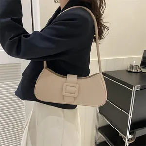 French style beige baguette bag with large square buckle shown on model shoulder