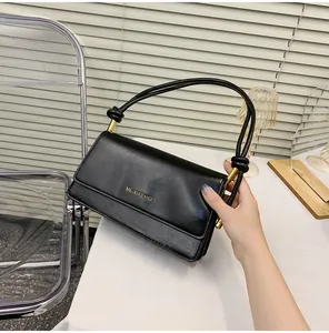 Detail of black rectangular bag with MEIXIAOMEI gold logo and knot shoulder straps