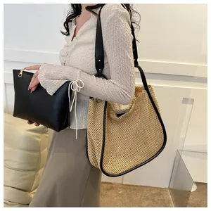 Dettaglio della borsa in paglia con finiture in pelle nera e pochette interna con zip dorata