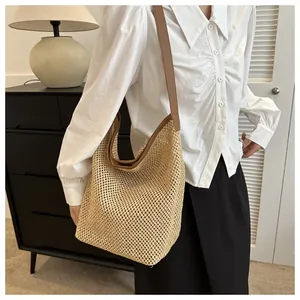 Détail du sac cabas en paille tissée main avec bandoulière en cuir dans un décor moderne